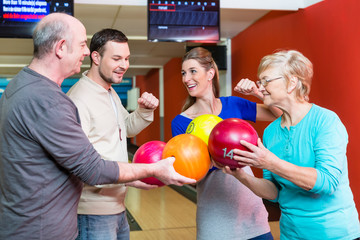 Fototapeta premium Happy family holding bowling ball