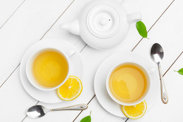 teapot and cups of tea on a white wooden background