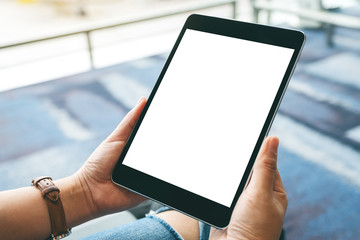 Mockup image of hands holding black tablet pc with blank white screen