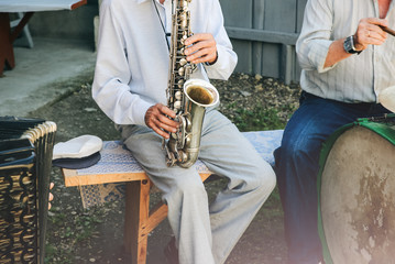 The band of traditional musicians are playing outdoors. Trumpet, drums and saxophone. Ukrainian ethno music at the wedding. National concept.