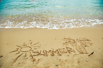 Summertime drawings in the sand - enjoying on a sandy beach.