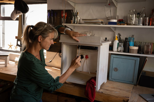 Female carpenter fixing a cabinet in workshop