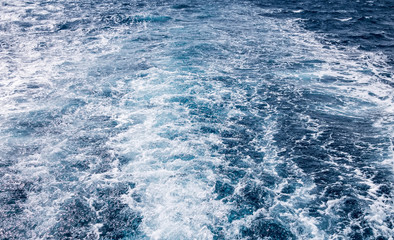 Water wake of cruise liner blue sea splash background.