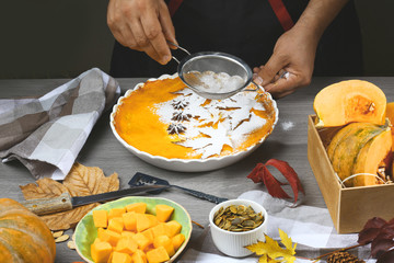 Pumpkin pie, tart made for Thanksgiving day. Fresh round bright orange homemade pumpkin pie in baking dish