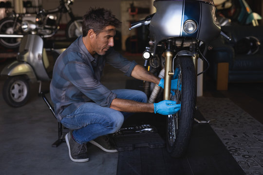 Bike mechanic repairing bike in garage 