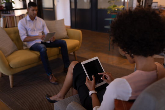 Business people using digital tablet in waiting room in office