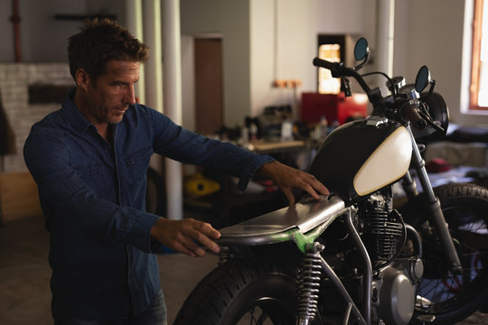 Bike mechanic fixing new seat in motorbike 