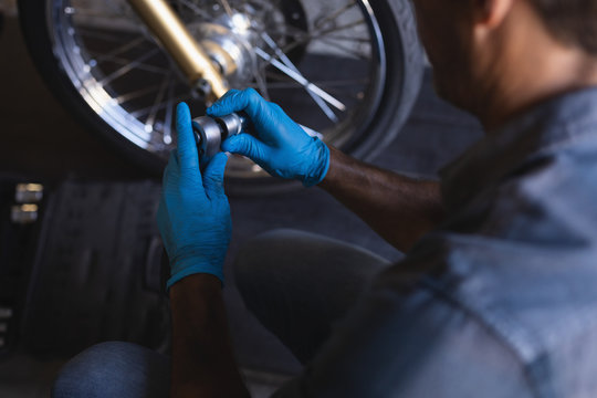 Bike mechanic working in garage with ratchet wrench