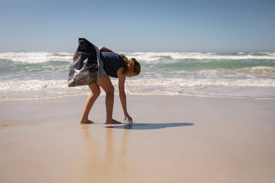 Female volunteer cleaning beach on a sunny day