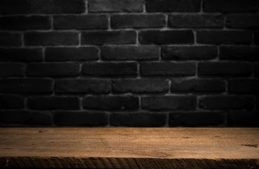 Old wooden table with brick background dark