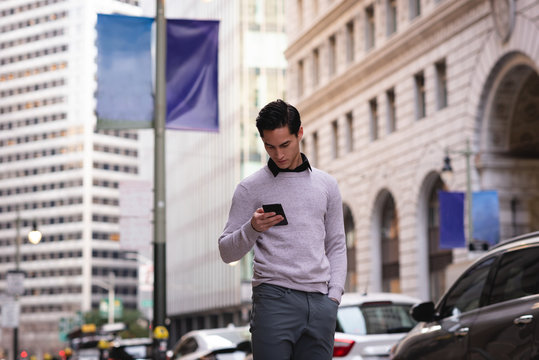 Man using mobile phone while standing on street 