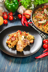 Traditional paella with chicken legs, sausage chorizo and vegeta