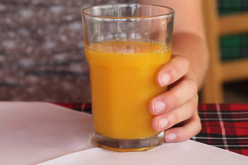hand with glass of orange juice