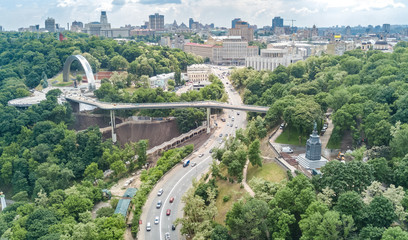 Aerial drone view of new pedestrian cycling park bridge construction, hills, parks and Kyiv cityscape from above, city of Kiev skyline, Ukraine
