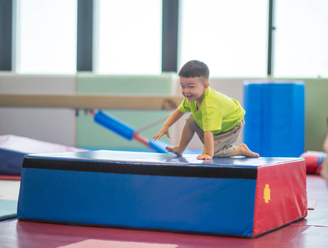 Little toddler boy working out at the indoor gym excercise