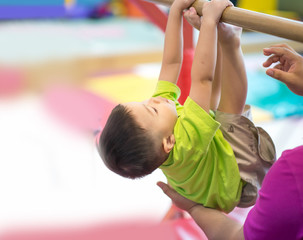 Little toddler boy working out at the indoor gym excercise