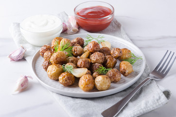 Setting a table for delicious dinner.Fried crusty new potatoes with garlic and dill, ketchup and tasty sauce