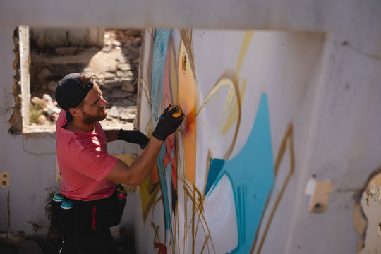 Graffiti Artist Spray Painting On Weathered Wall Room