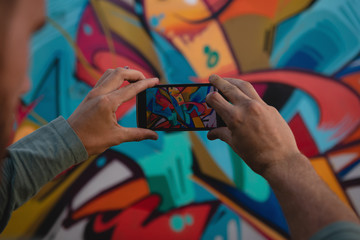 Graffiti artist capturing photo of painted wall