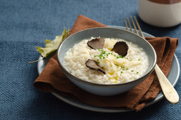 Risotto with black truffle and parmesan cheese in blue plate. Copyspace.