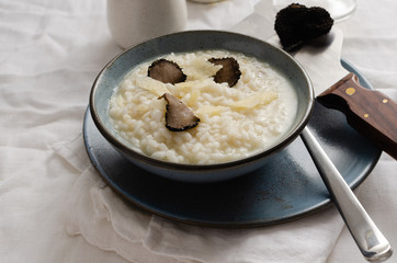 Risotto with black truffle and parmesan cheese in blue plate. Copyspace.