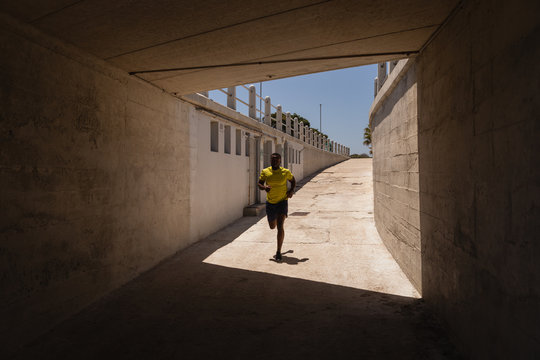 Man running under the bridge on a sunny day