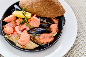 seafood salmon and mussels in a black skillet