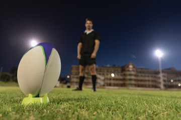 Male rugby player standing with rugby ball in the stadium
