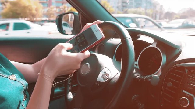 Woman using mobile phone when she is driving car. Dangerous on traffic. Distracted female driver on road, texting on automobile. 