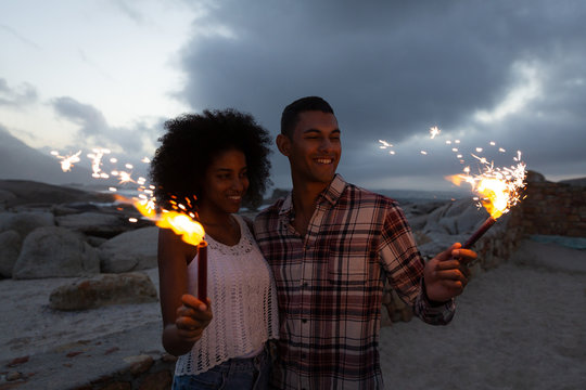 Couple enjoying with fire cracker on the beach 