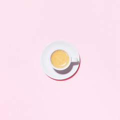 A cup of coffee on pink background. Trendy minimal styled flat lay photography with cappuccino.