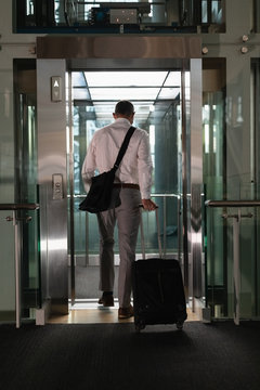 Businessman with travel bag entering the elevator