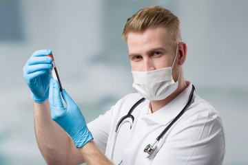 Scientist with medical face mask and blood probe