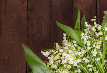 bouquet of white lilies of the valley on a wooden background with a copy of space