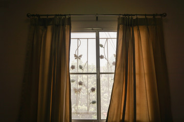 close up curtain at bedroom window with morning sunlight in holidays