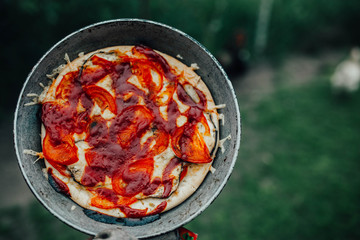 rustic pizza with tomatoes and ketchup on the nature outside  