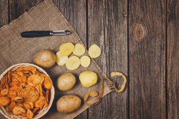 Fototapeta premium Heap of potato chips in vintage bowl on old wooden table background close-up with copy space for your text