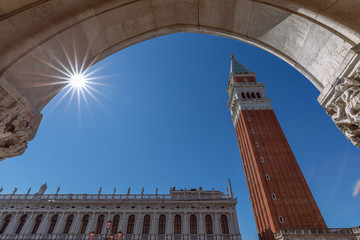 Fototapeta na wymiar View from the arch of the Doge's Palace (Palazzo Ducale) to the famous St. Mark's Bell Tower (Campanile di San Marco). Venice, Italy