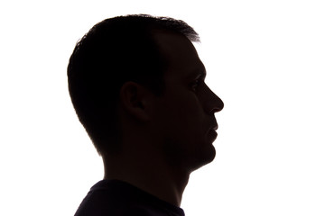 Portrait of a young man, side view - dark isolated silhouette