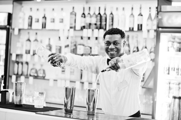 African american bartender working behind the cocktail bar. Alcoholic beverage preparation.
