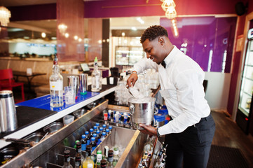 African american bartender at bar with ice bucket. Alcoholic beverage preparation.