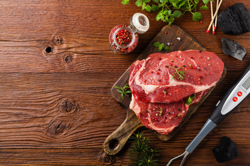 Raw beef steak, ready for grilling. Grill accessories. Concept. Free space for description. Top...