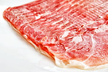 jamon ham isolated on white background closeup crop view of spanish italian national food slices of prosciutto meat in natural light color of crudo pork with fat on plate world cuisine concept