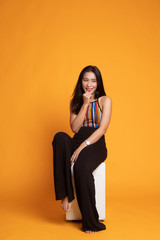 Portrait of beautiful young Asian woman in colorful shirt is sittng