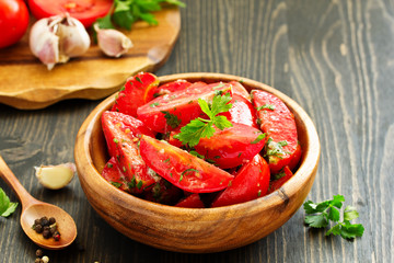 Appetizer of salted tomato with garlic and herbs.