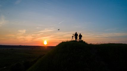 Photographers shoot sunset. Air view