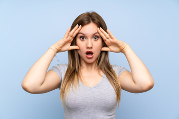 Teenager girl over isolated blue wall with surprise expression