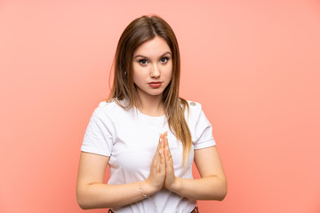 Fototapeta premium Teenager girl over isolated pink wall pleading