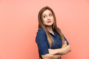 Fototapeta premium Teenager girl over isolated pink background making doubts gesture while lifting the shoulders