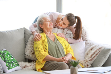 Caregiver with senior woman in nursing home - obrazy, fototapety, plakaty